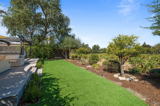 view of yard featuring fence, a deck, and a pergola