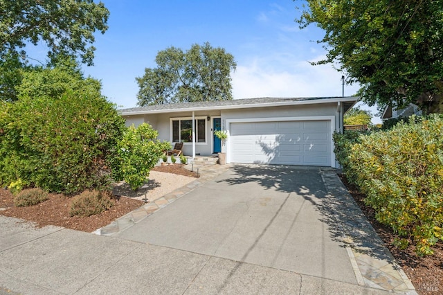 ranch-style home featuring a garage, driveway, and stucco siding