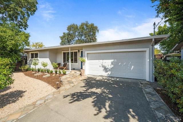 ranch-style house with an attached garage, concrete driveway, and stucco siding