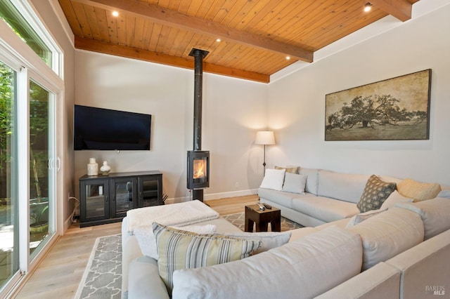 living area with wood ceiling, a wood stove, beam ceiling, and wood finished floors