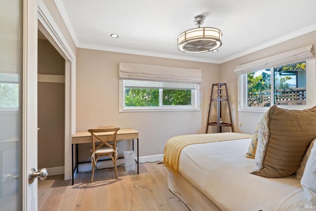 bedroom featuring baseboards, ornamental molding, recessed lighting, and light wood-style flooring