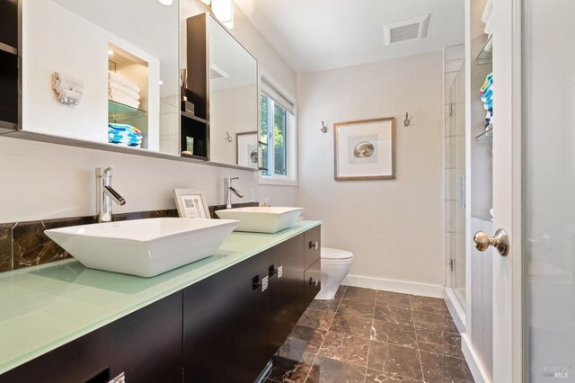 full bath with a sink, toilet, marble finish floor, and visible vents