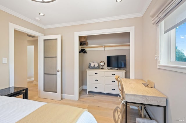 bedroom with baseboards, ornamental molding, a closet, and light wood-style floors