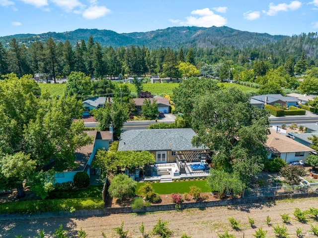 birds eye view of property with a mountain view and a wooded view