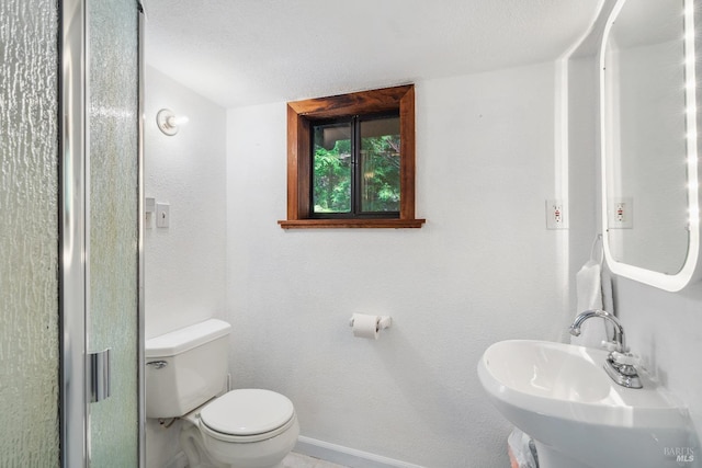 bathroom with a sink, baseboards, and toilet