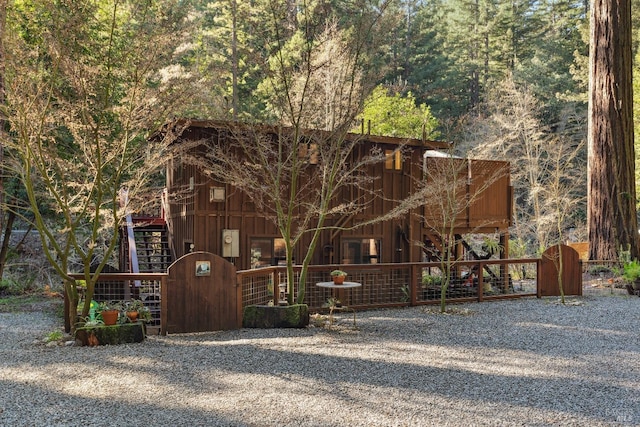 view of front of home featuring board and batten siding, fence, and a gate