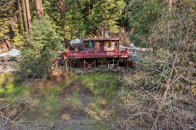 back of house with stairway, a forest view, and a wooden deck