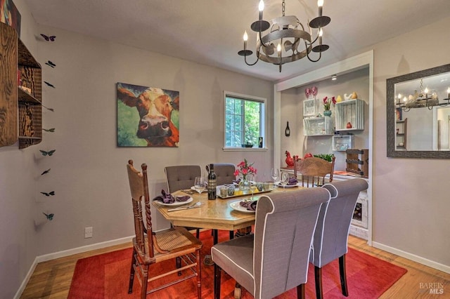 dining area featuring an inviting chandelier and hardwood / wood-style flooring