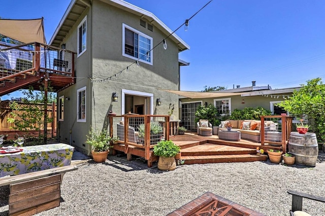 back of property featuring a wooden deck, outdoor lounge area, and a patio