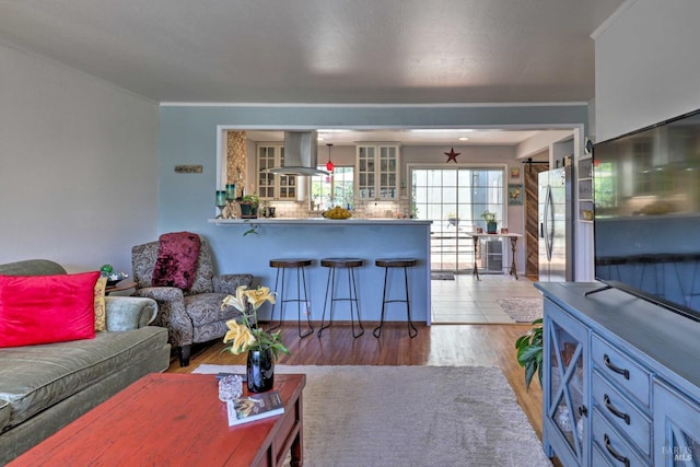 living room with crown molding and light hardwood / wood-style floors