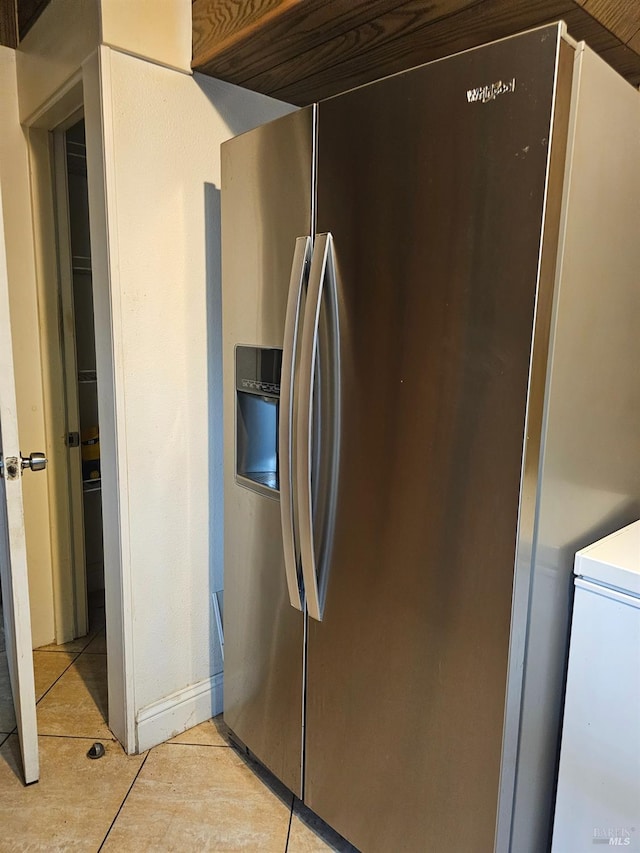 kitchen with light tile patterned flooring and stainless steel fridge with ice dispenser