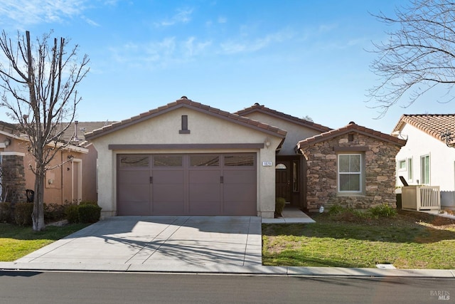 mediterranean / spanish-style home with central AC unit, a front yard, and a garage