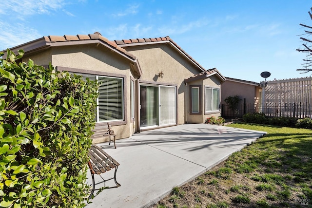 back of house featuring a lawn and a patio