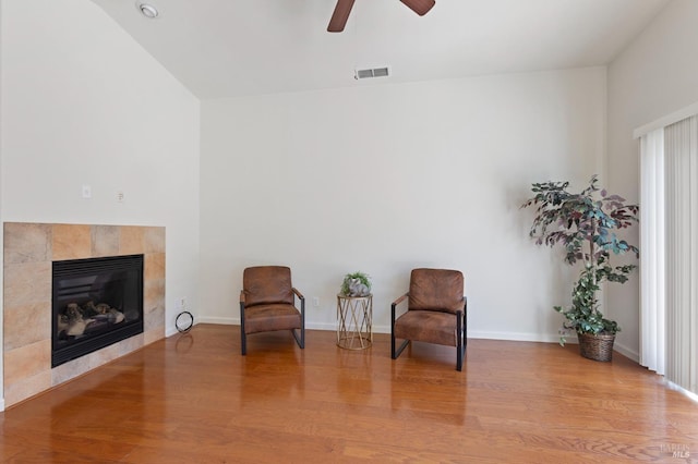 sitting room with ceiling fan, light wood-type flooring, and a fireplace