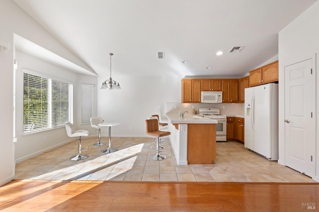 kitchen with pendant lighting, white appliances, kitchen peninsula, a chandelier, and light tile patterned floors