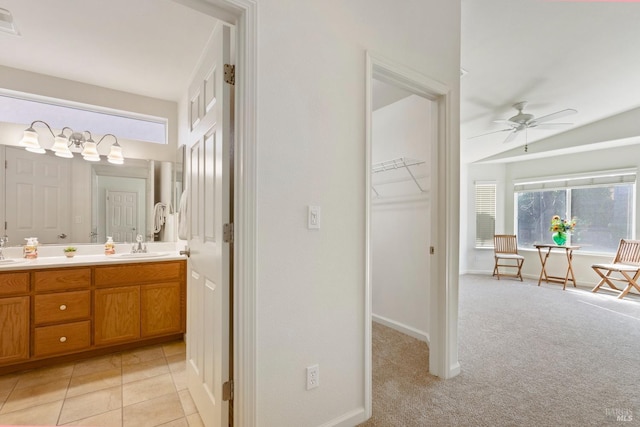 bathroom with vaulted ceiling, ceiling fan, tile patterned floors, and vanity