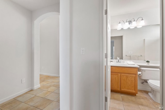 bathroom with toilet, vanity, and tile patterned floors