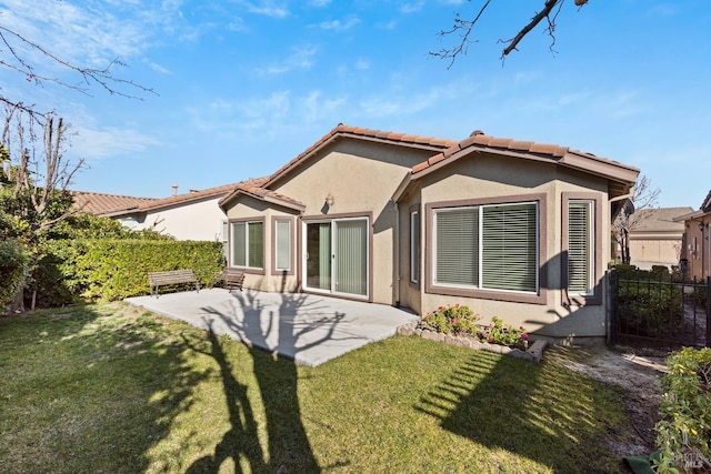 rear view of property with a yard and a patio