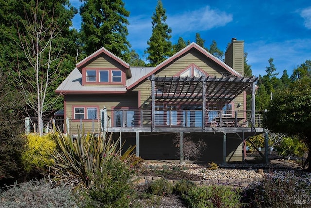 rear view of property featuring a pergola and a wooden deck