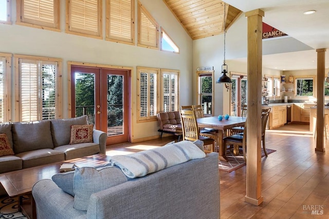 living room with french doors, hardwood / wood-style flooring, high vaulted ceiling, wooden ceiling, and decorative columns