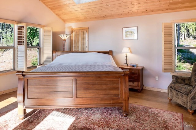 bedroom featuring lofted ceiling with skylight, wood ceiling, and light hardwood / wood-style flooring