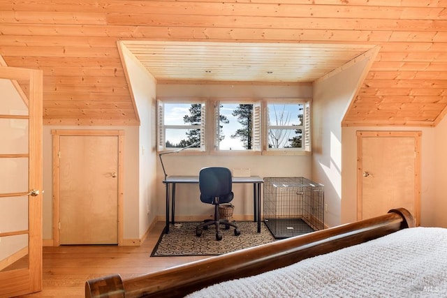 bedroom with wood ceiling, wood walls, and light hardwood / wood-style flooring