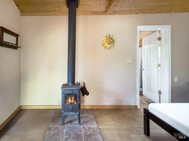 interior details featuring wood ceiling, a wood stove, and beam ceiling