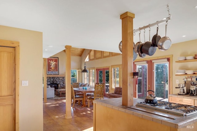 kitchen with lofted ceiling, stainless steel gas cooktop, plenty of natural light, and tile countertops