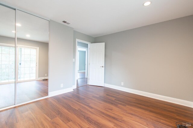 unfurnished bedroom featuring dark hardwood / wood-style flooring and a closet