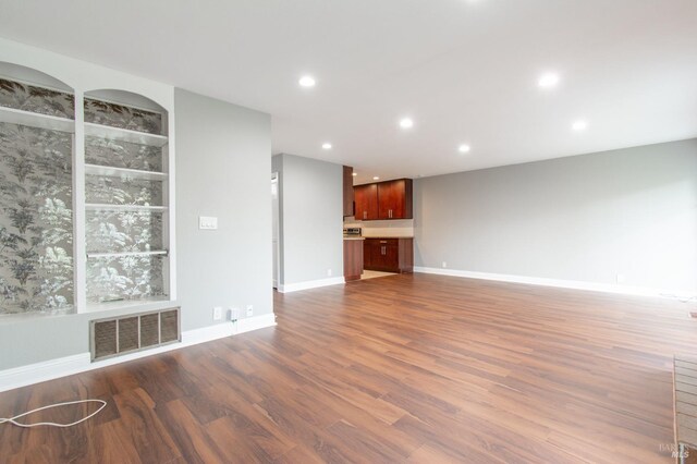 unfurnished living room with dark hardwood / wood-style floors and a tiled fireplace