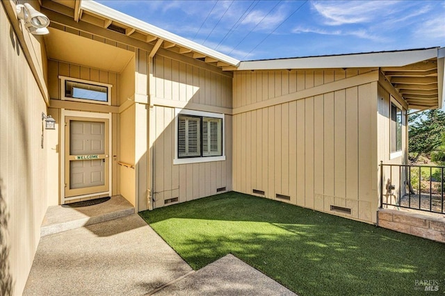 property entrance with visible vents, crawl space, and a lawn