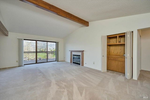 unfurnished living room with light carpet, a textured ceiling, a fireplace with flush hearth, and vaulted ceiling with beams