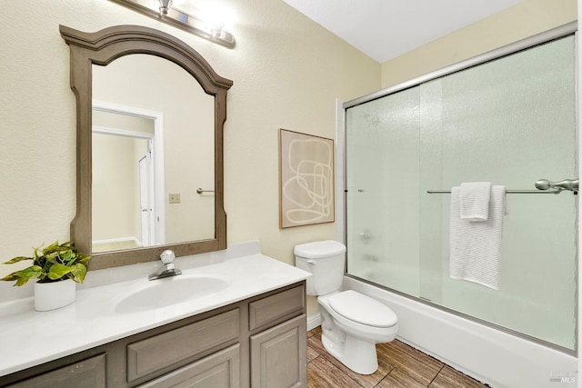 full bathroom featuring vanity, toilet, and bath / shower combo with glass door