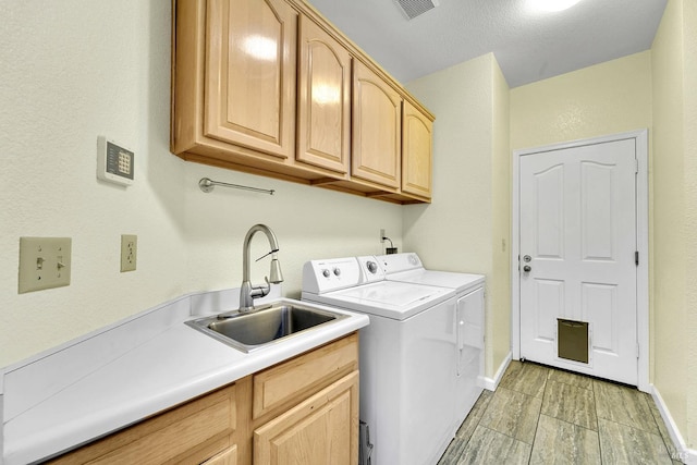 laundry room with washer and clothes dryer, cabinets, and sink