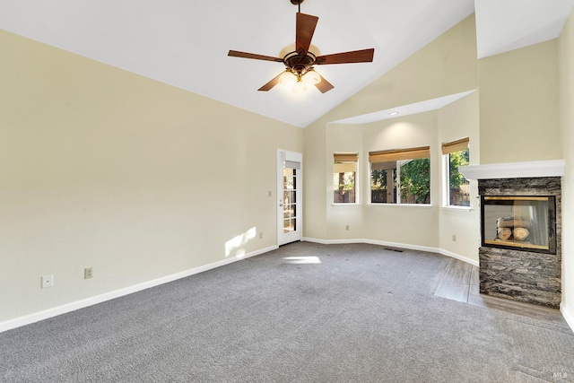 unfurnished living room with carpet, high vaulted ceiling, a stone fireplace, and ceiling fan