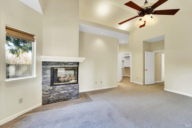 unfurnished living room with carpet flooring, ceiling fan, and a fireplace