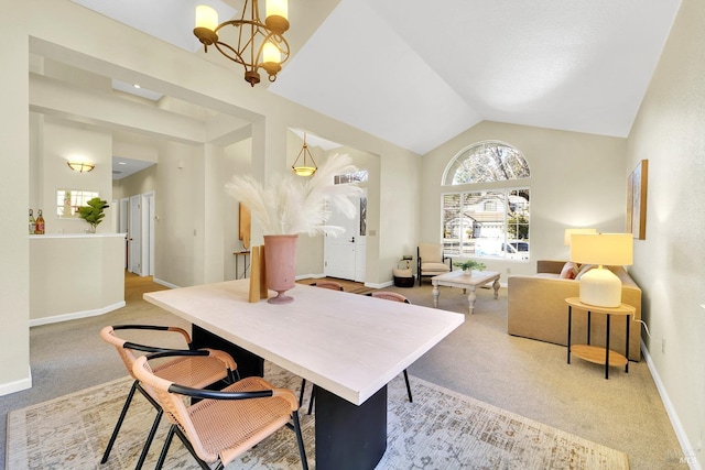 carpeted dining space with a notable chandelier and vaulted ceiling