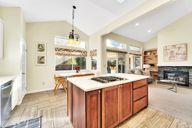 kitchen featuring gas stovetop, decorative light fixtures, dishwasher, a stone fireplace, and lofted ceiling