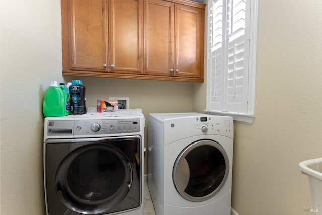 clothes washing area with cabinets and independent washer and dryer