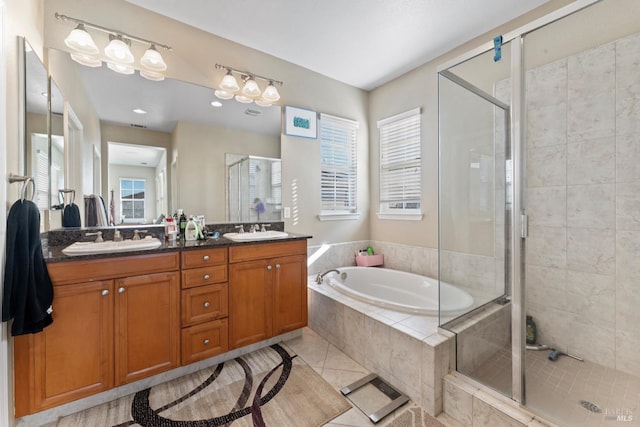 bathroom featuring independent shower and bath, vanity, and tile patterned floors