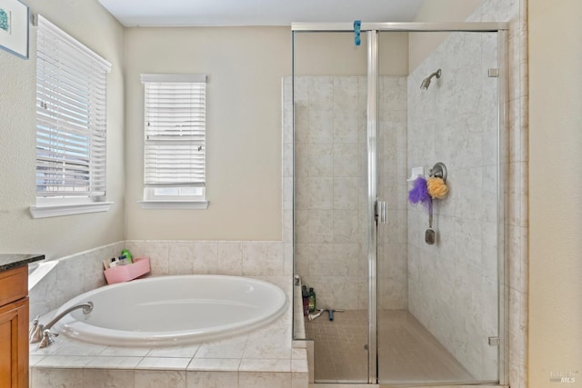 bathroom featuring vanity and shower with separate bathtub