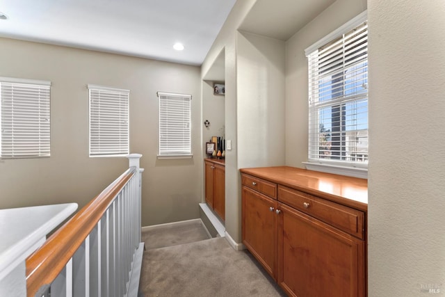 hallway featuring light colored carpet