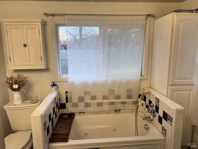 bathroom with a tub to relax in, a wealth of natural light, and toilet