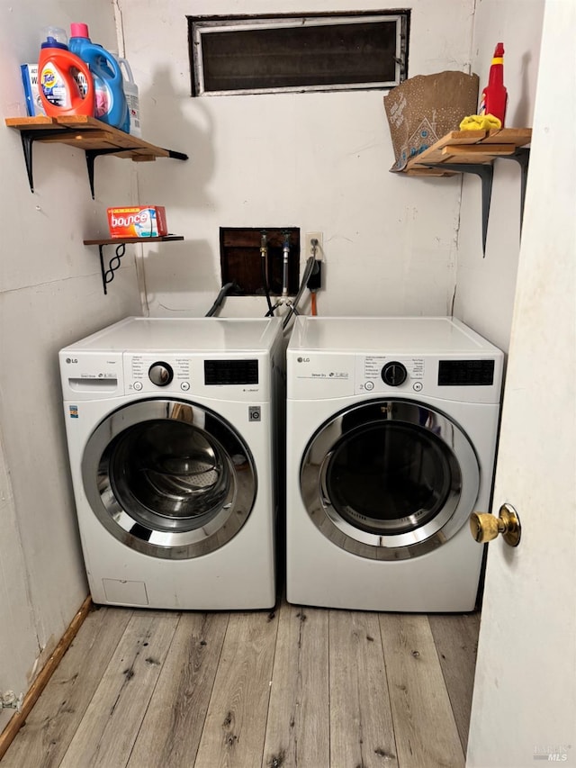 laundry area featuring light hardwood / wood-style flooring and washing machine and clothes dryer