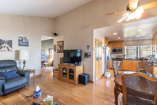 living room featuring high vaulted ceiling, light hardwood / wood-style flooring, and ceiling fan