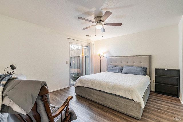 bedroom featuring ceiling fan, a textured ceiling, wood finished floors, visible vents, and access to outside