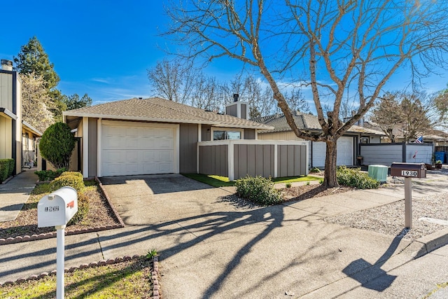 view of front facade with central AC unit, a fenced front yard, an attached garage, concrete driveway, and a chimney