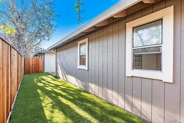 view of side of property featuring a fenced backyard and a yard