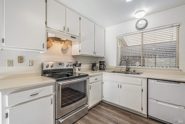 kitchen featuring white dishwasher, under cabinet range hood, dark wood-type flooring, a sink, and stainless steel electric range oven