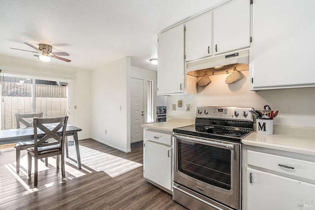 kitchen featuring dark wood-type flooring, light countertops, under cabinet range hood, and stainless steel electric stove